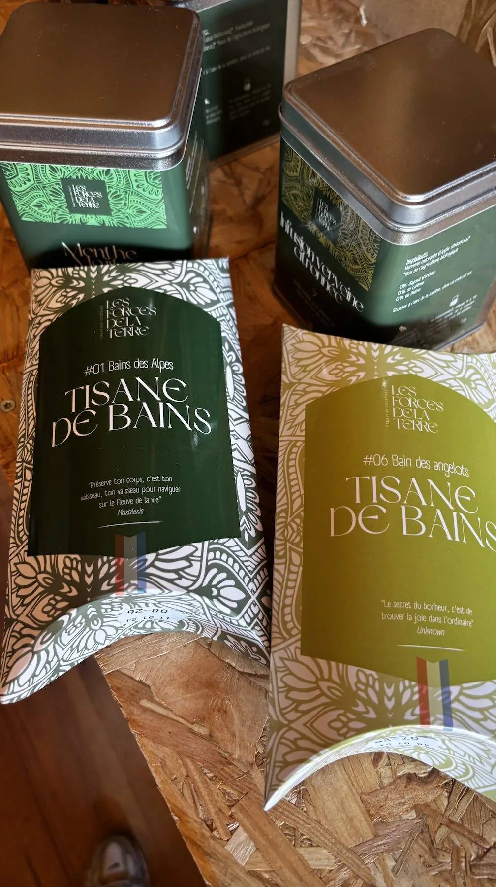 Boîtes de tisanes et sachets de plantes pour le bain posés sur du bois